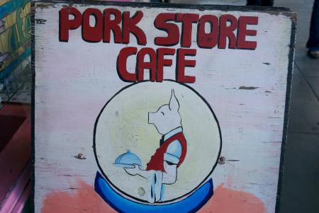 Image of a pig being  a waiter on a Pork Store Cafe Sign