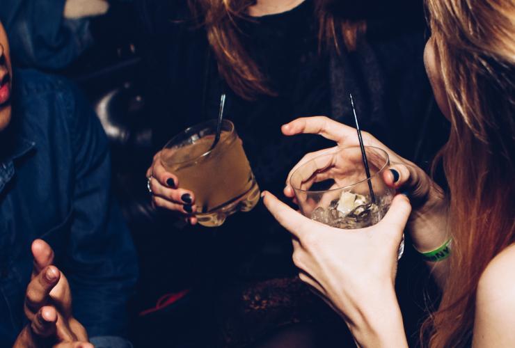 girls laughing with drinks and cocktails at a bar