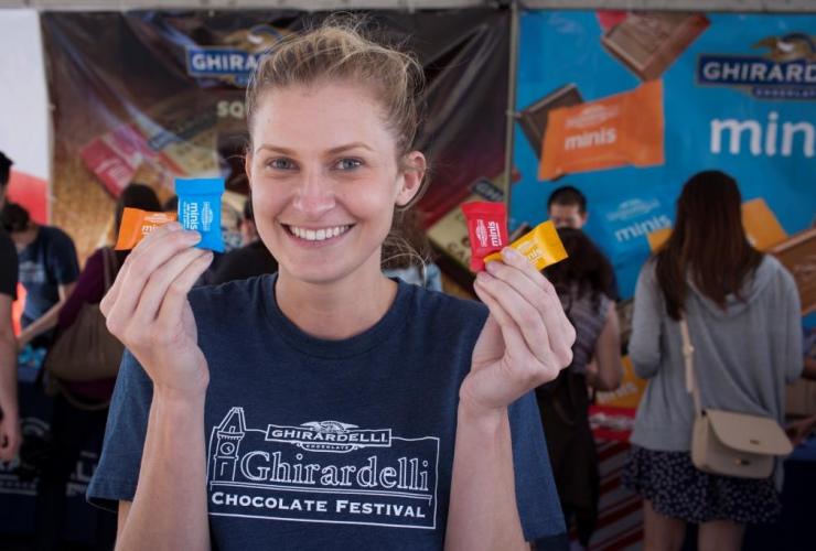 girl holding up pieces of ghirardelli chocolate
