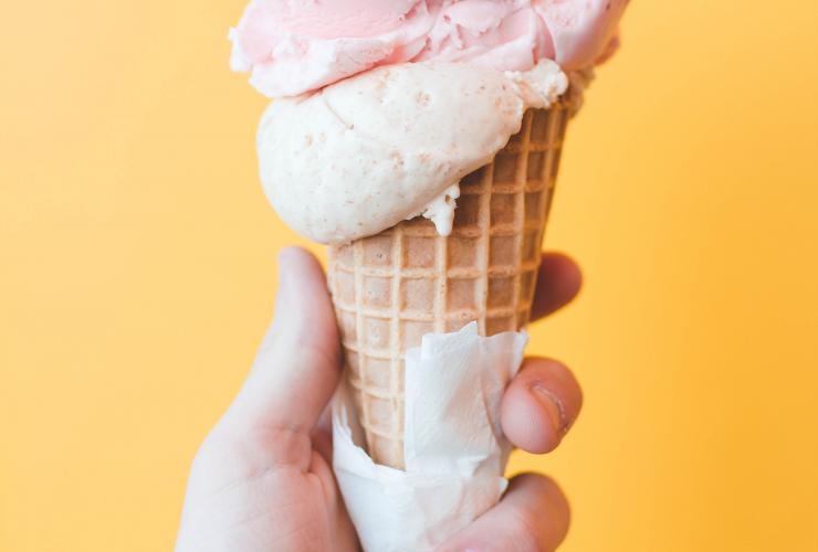 A hand holds an ice cream cone