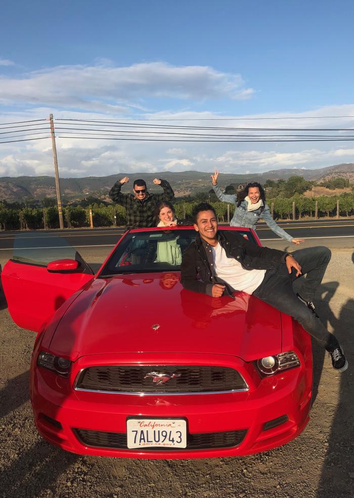 4 people sit on a red car