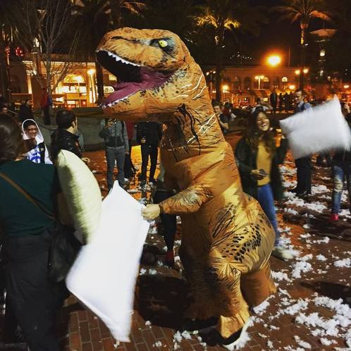 A person in a large T Rex costume participates in the Valentine&#039;s Day Pillow Fight in San Francisco.